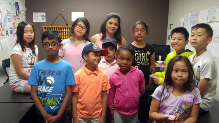 Picture of a lady teacher posing with students at AbacusMaster, Canada branch