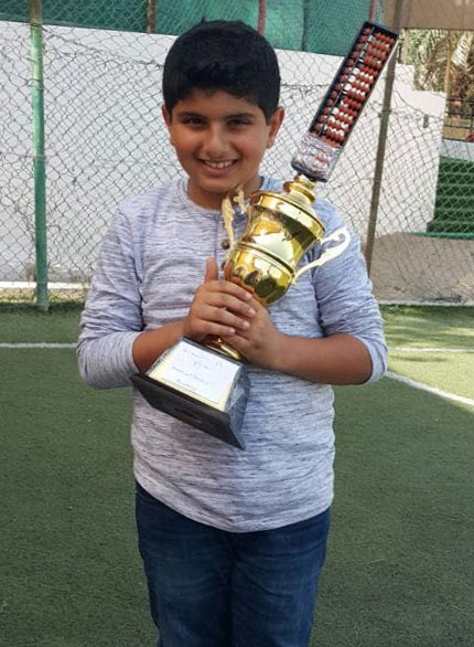 Picture of a student  posing with the trophy he won at an abacus competition at AbacusMaster, Muscat branch