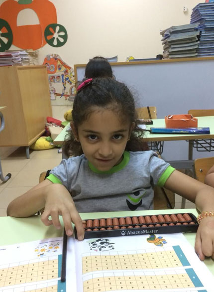 Picture of a student working out problems on an abacus board during abacus certification exam at AbacusMaster, Muscat branch