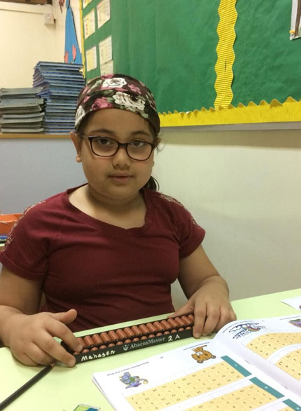 Picture of a student posing with an abacus rod during abacus certification exam at AbacusMaster, Muscat branch