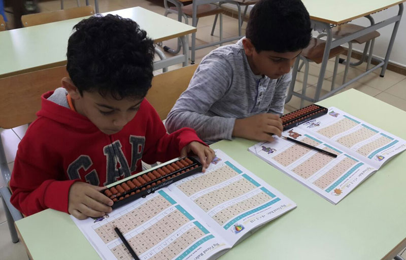 Picture of students working out problems on an abacus board at AbacusMaster, muscat branch
