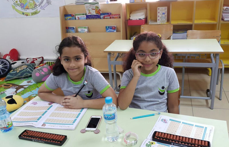 Picture of students posing with an abacus board for a picture at AbacusMaster, Muscat branch