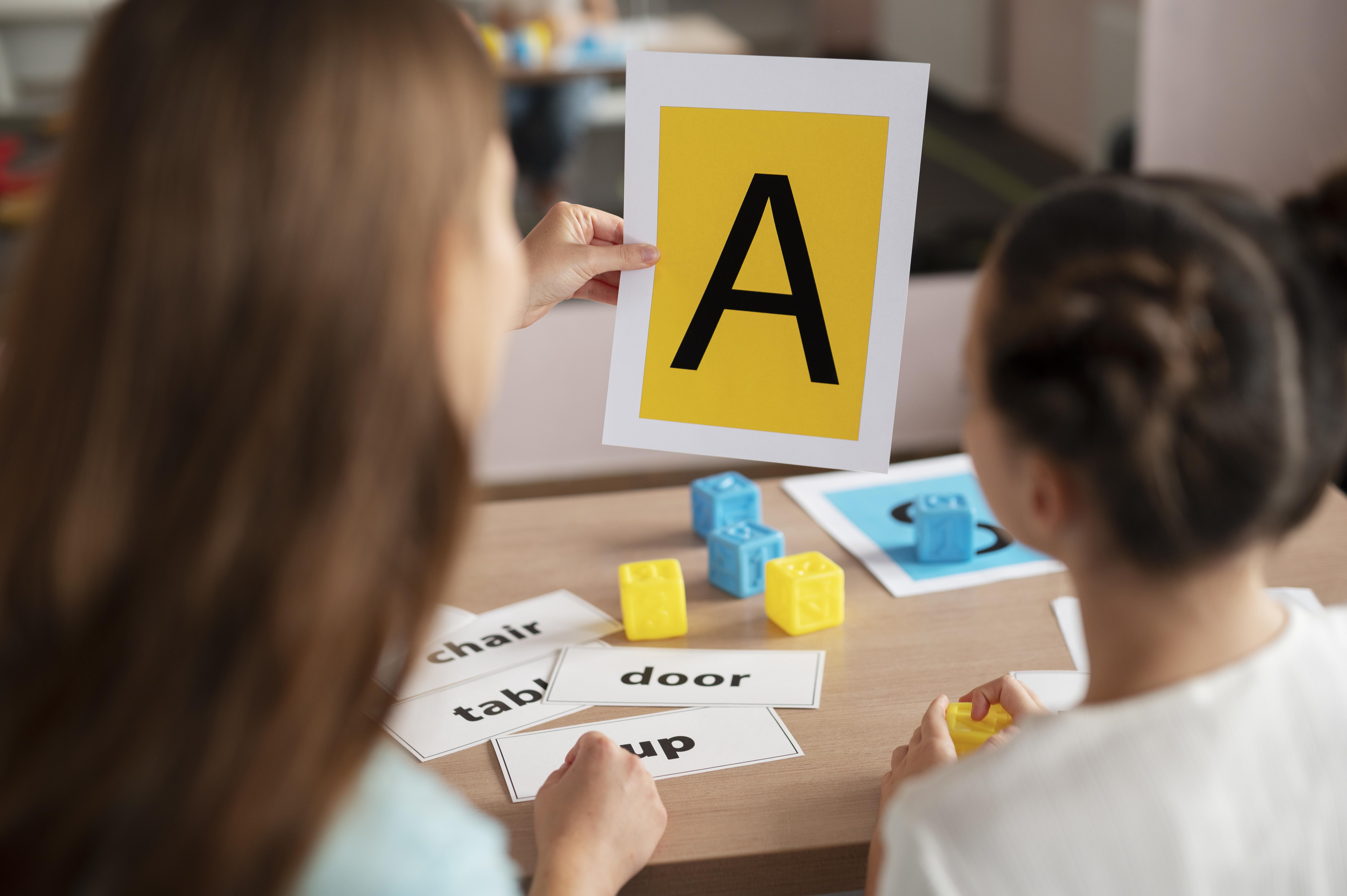 a box containing English letters with happy kids around and on the box, with a signal board written ‘English’