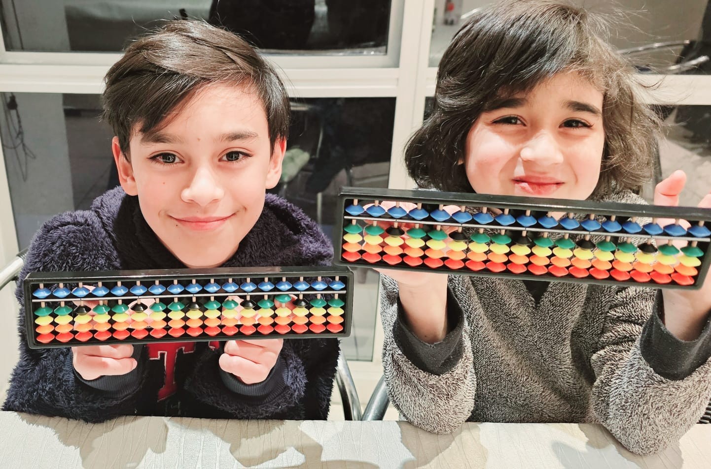 Two kids holding abacus