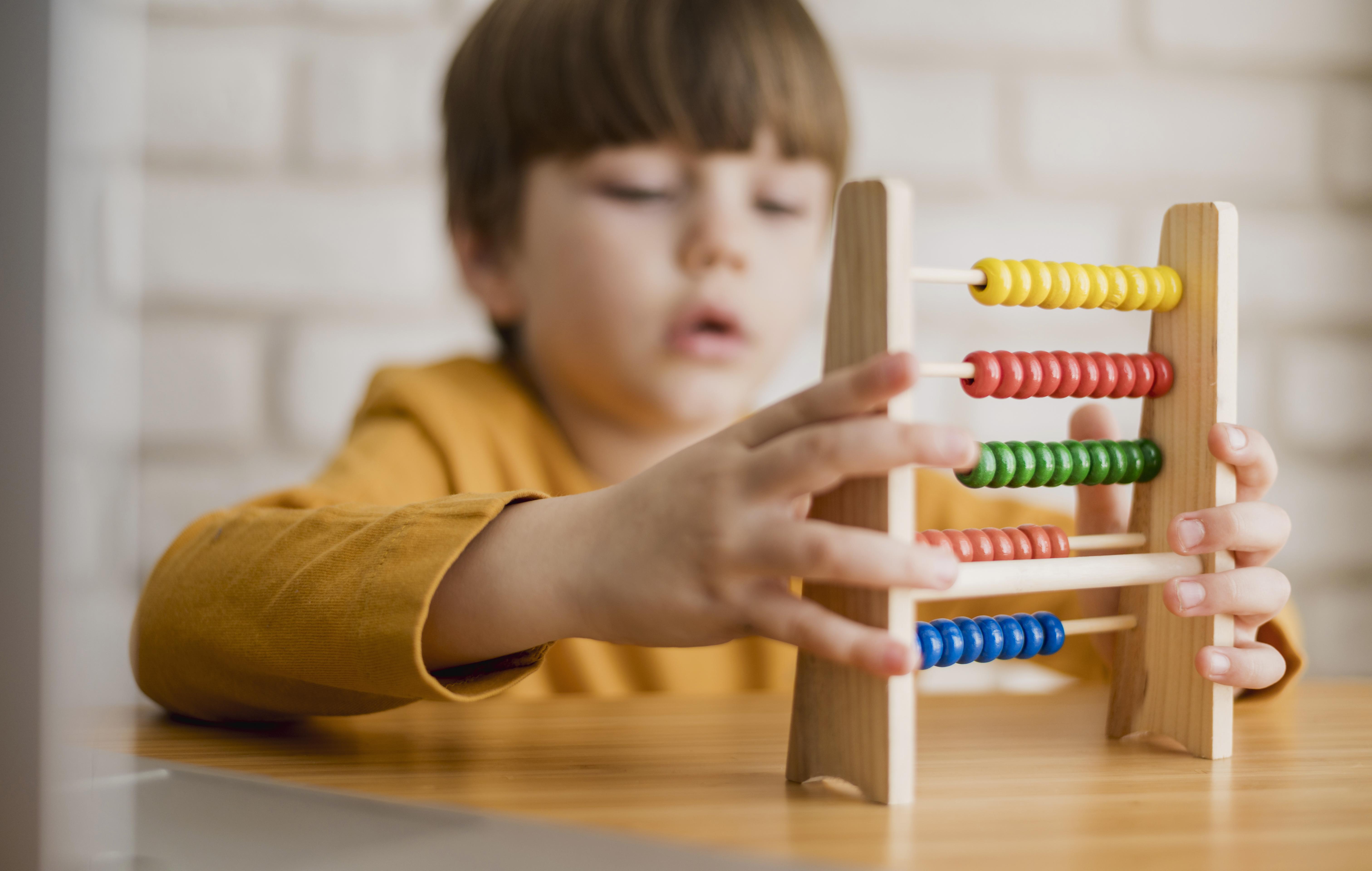 Child counting beads on small abacus
