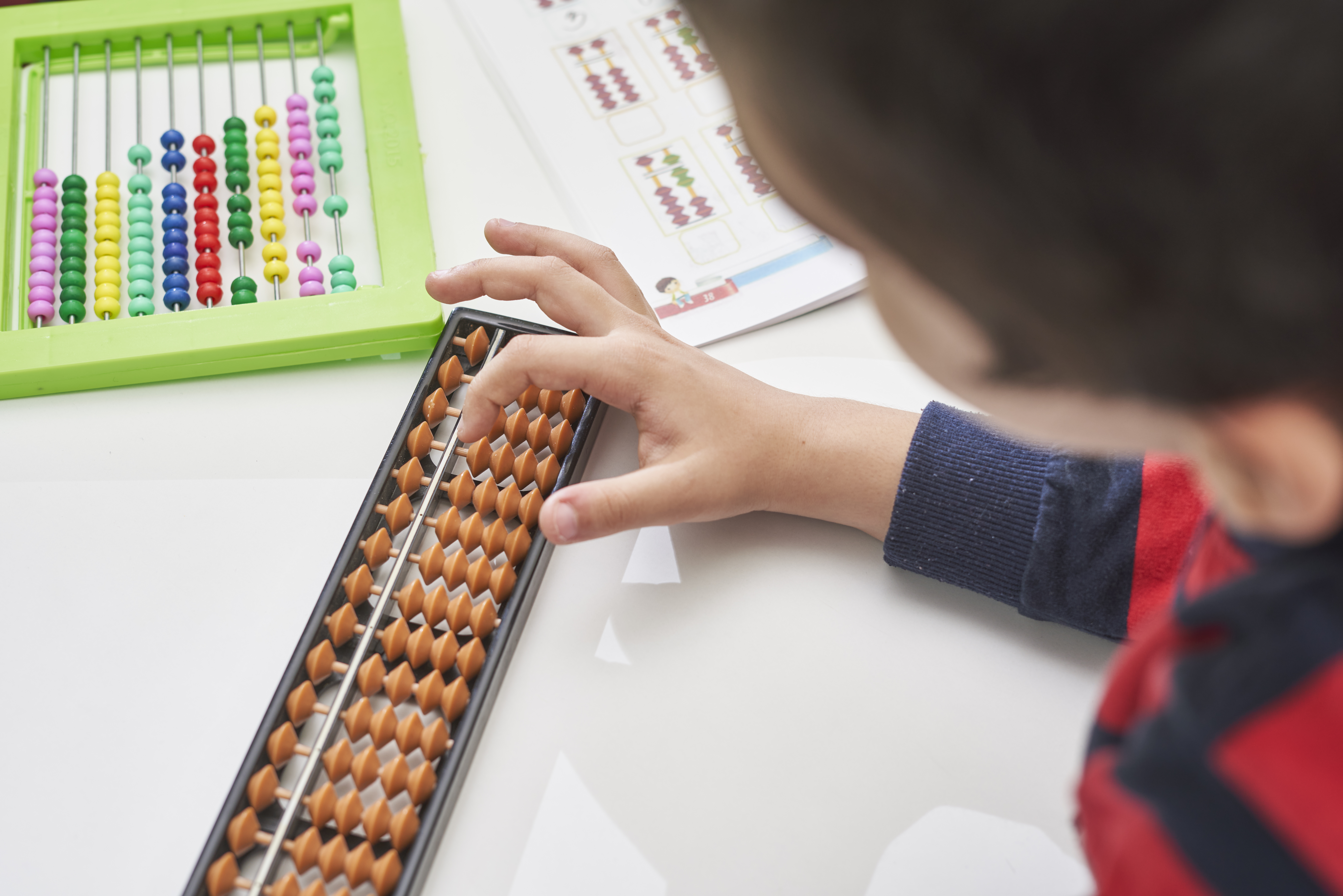 A child works with an abacus, a tool for mathematics.