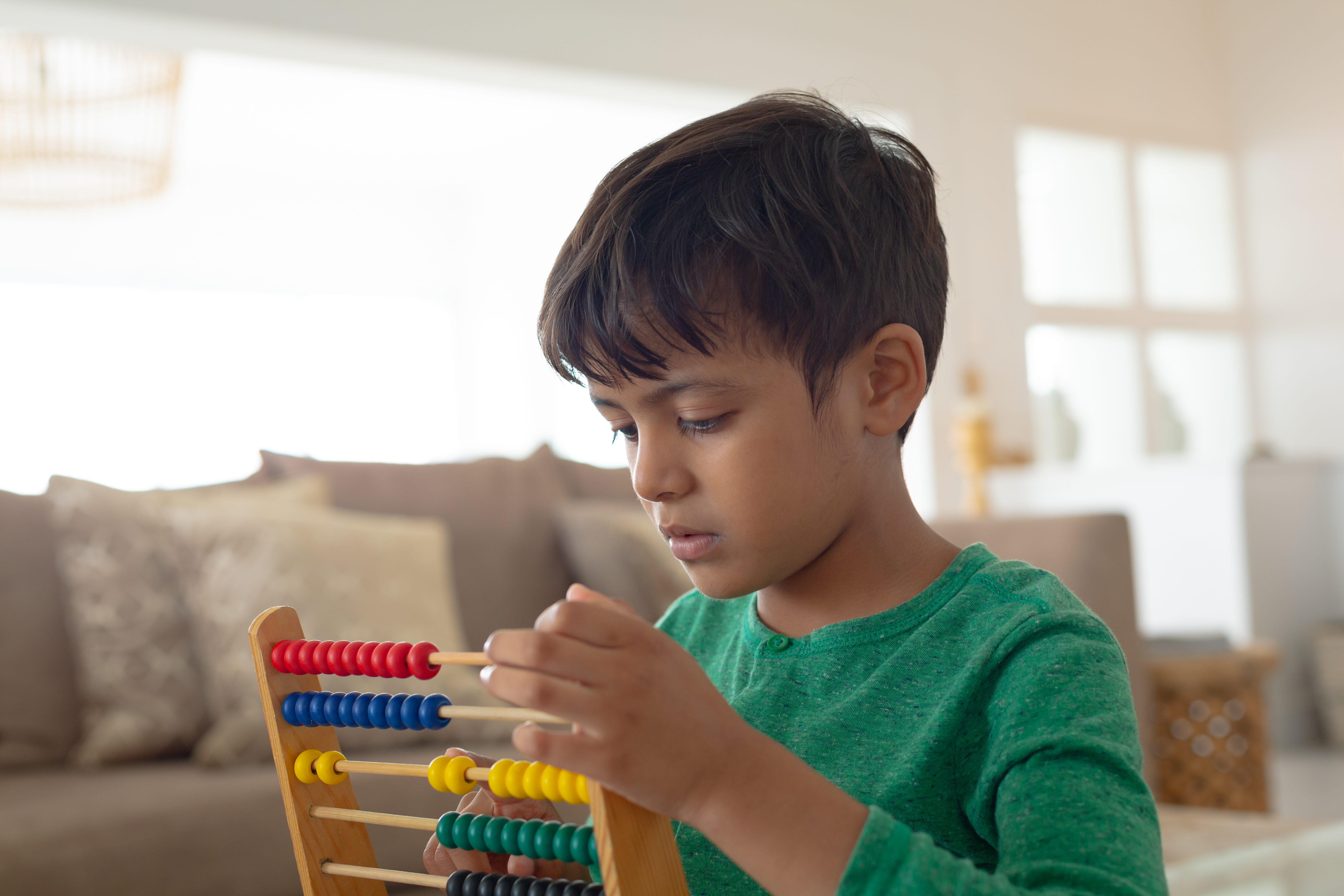 A child practices arithmetic on a abacus.